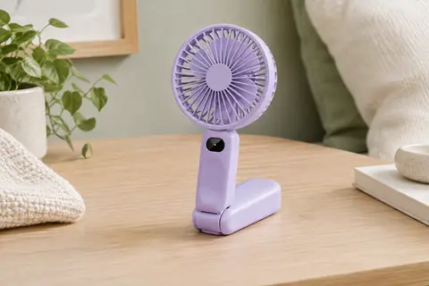 Mini ventilateur portable violet à cinq pales posé sur un bureau en bois clair